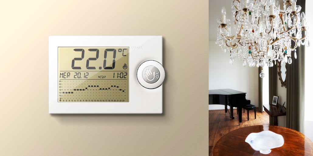 Vimar thermostat with mechanical levers for simplified programming and large LCD display for maximum readability with push wheel user interaction design by quickpartners+ in closed state in classic room